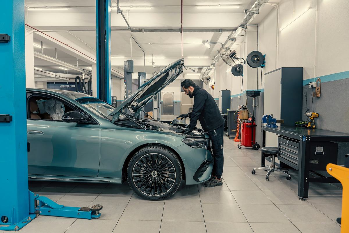 Een mechanieker werkt aan een wagen op de brug