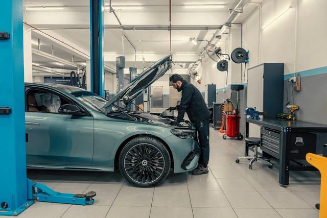 Een mechanieker werkt aan een wagen op de brug